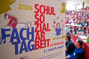 Flyer des Fachtages mit unscharfem Auditorium im Hintergrund